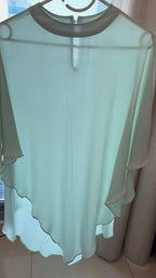 Light green blouse with scalloped edges on a hanger