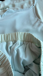 Light blue fabric with a focus on the waistband and bottom hem.
