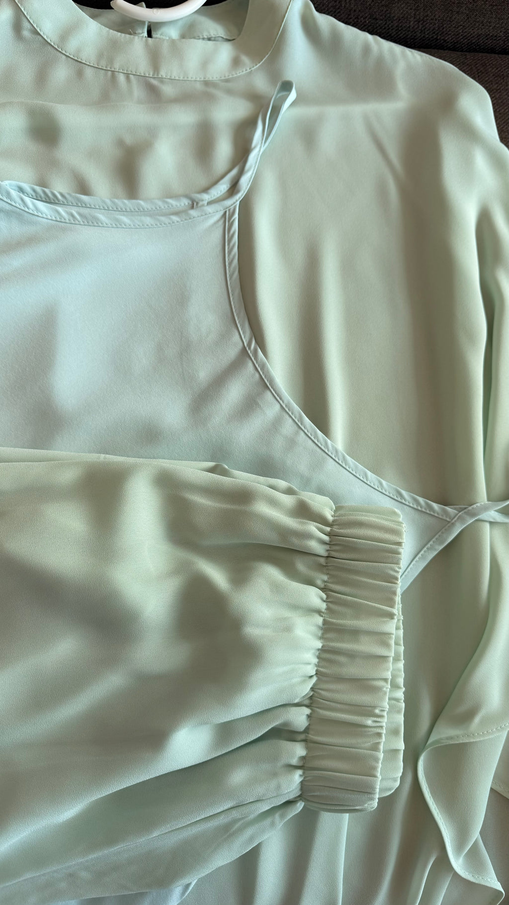 Light-colored top with a zipper detail on a neutral background