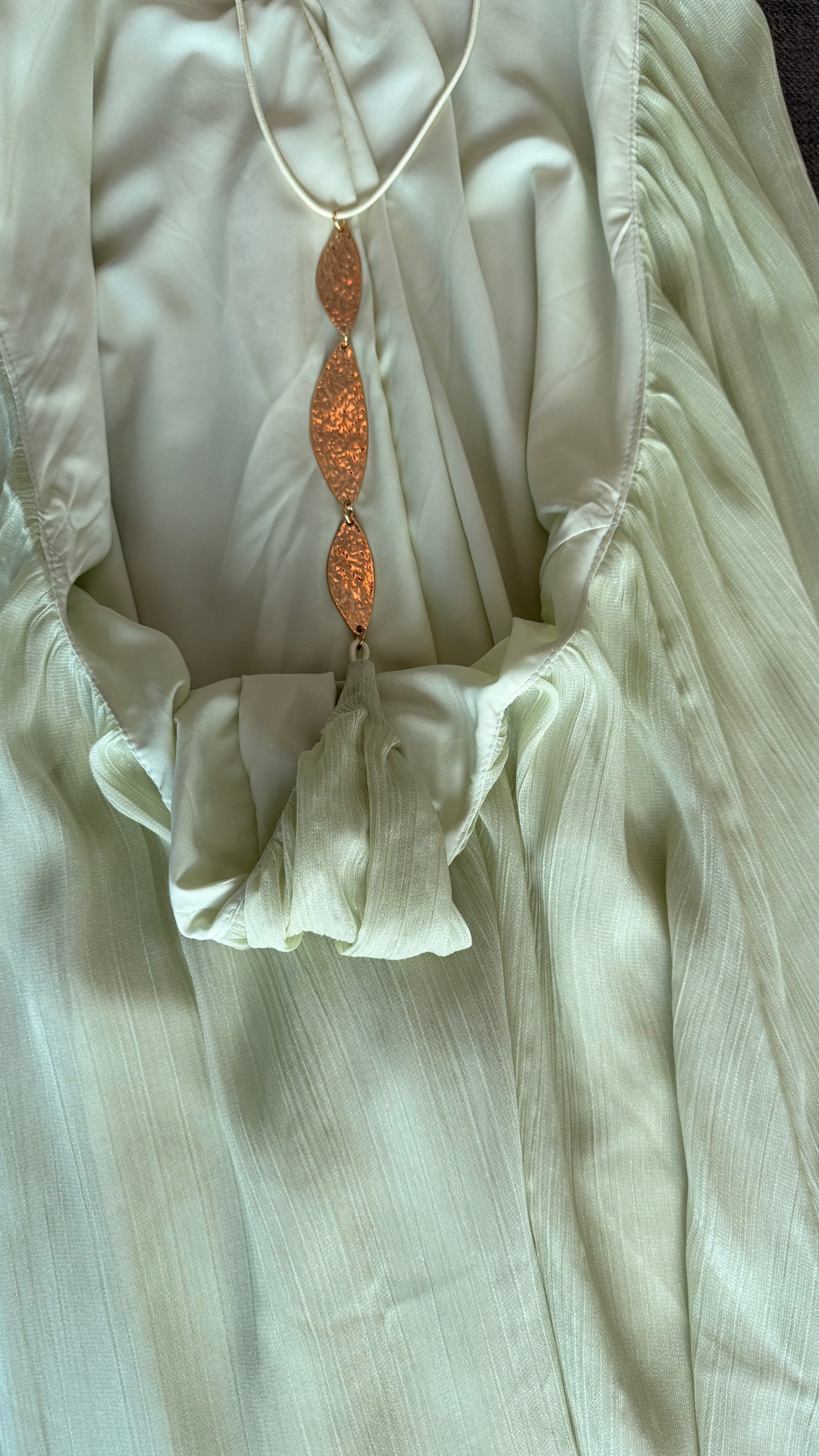 dress with a large pendant on a green fabric