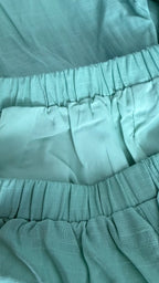 Close-up of teal fabric with a focus on texture and pattern.