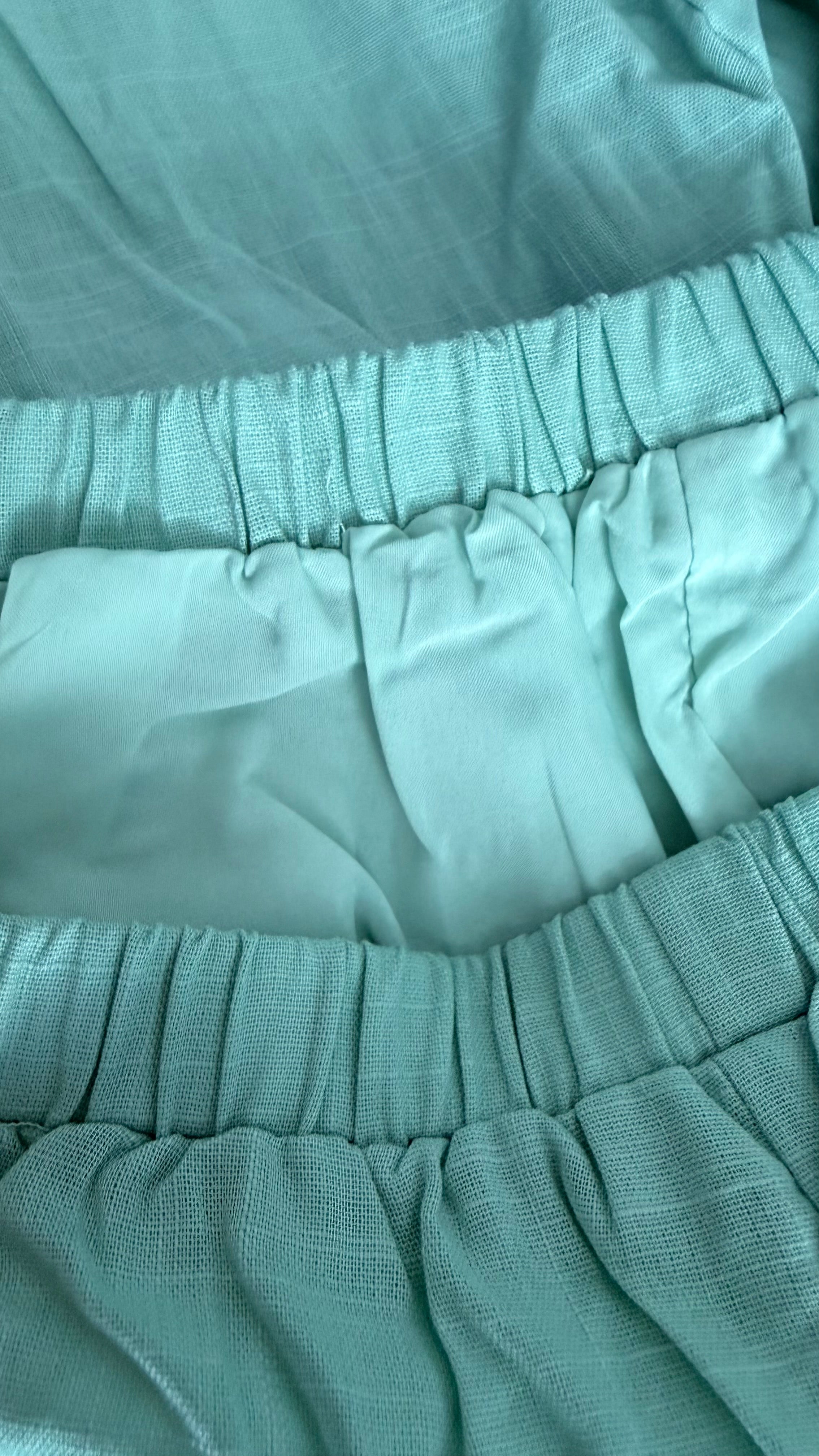 Close-up of teal fabric with a focus on texture and pattern.
