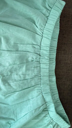 Close-up of teal fabric with a brown background