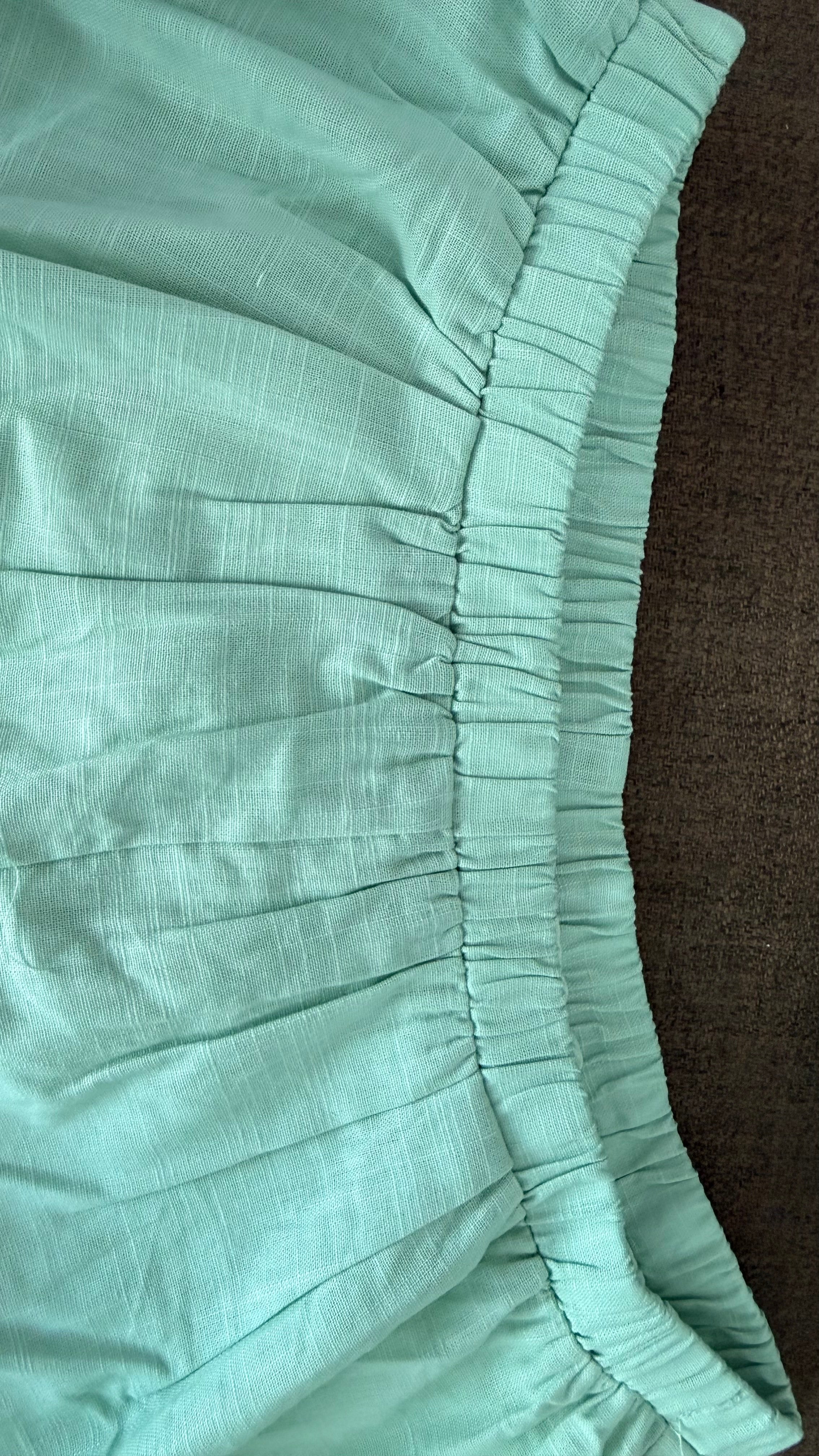 Close-up of teal fabric with a brown background