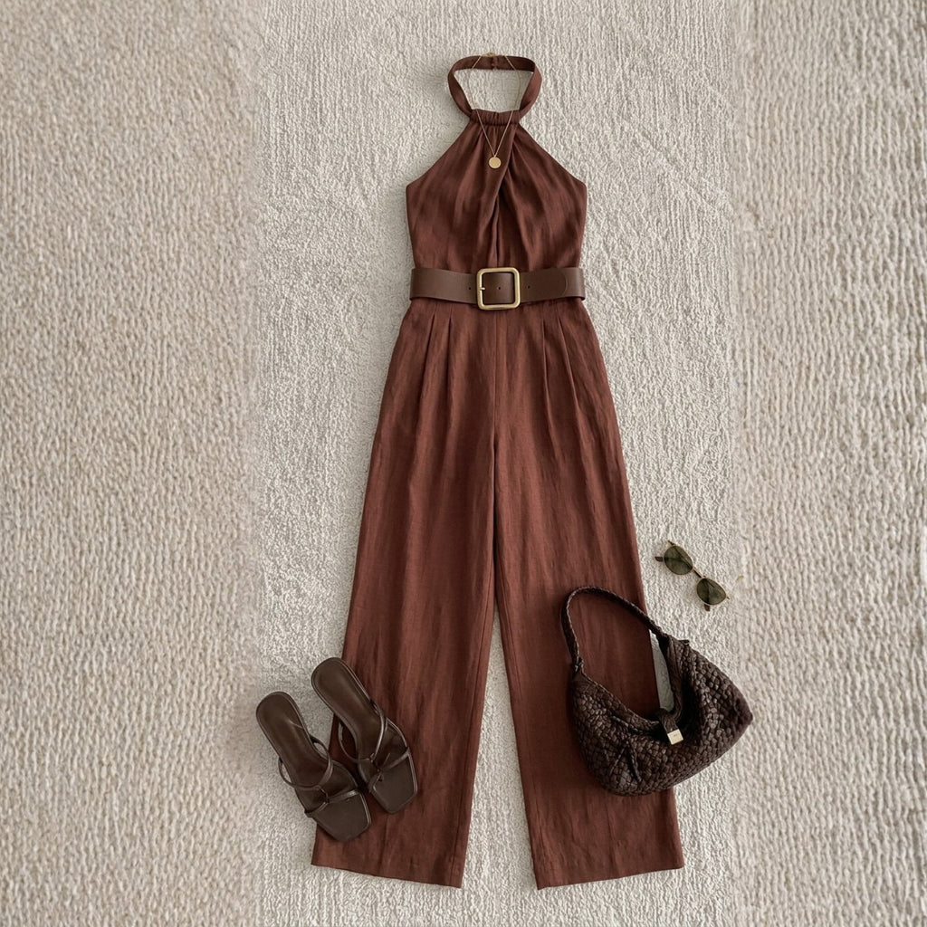Brown jumpsuit with accessories on a textured beige background