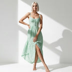 Woman wearing a light green dress with a slit on a white background