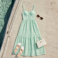 Mint green dress with accessories on a wooden deck by a pool