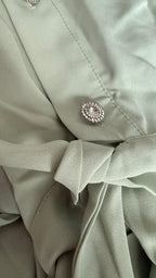 Close-up of a light green fabric with a decorative button.