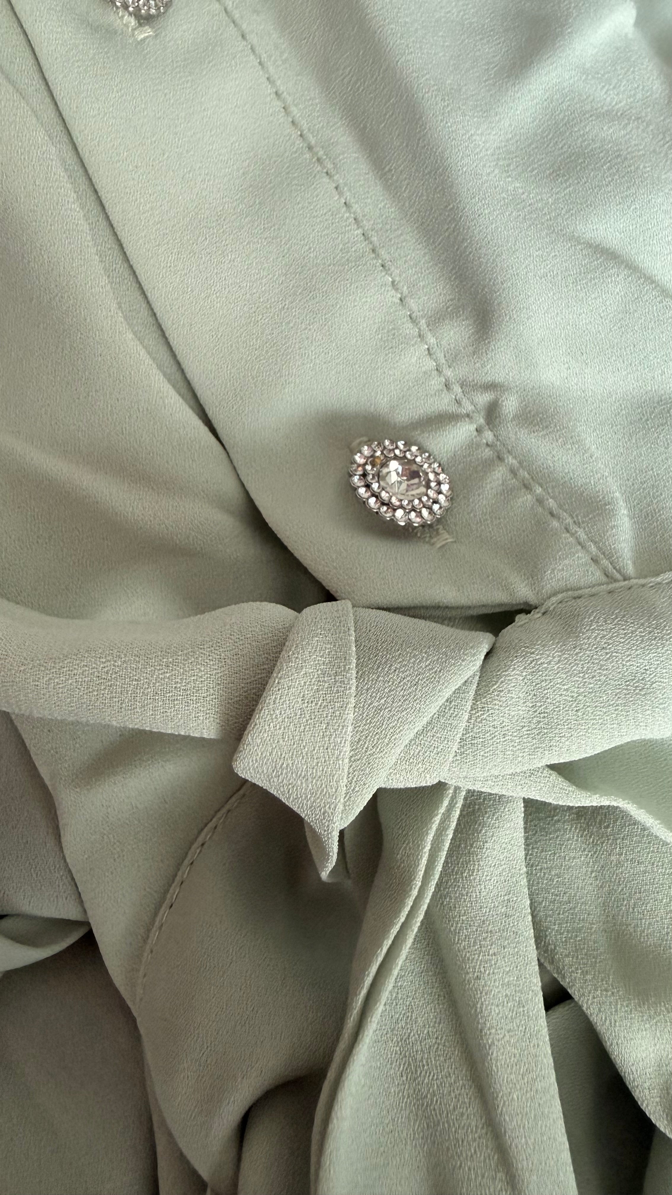 Close-up of a light green fabric with a decorative button.