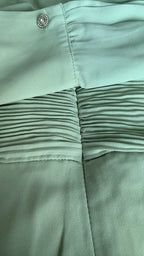 Close-up of light green fabric with a button detail