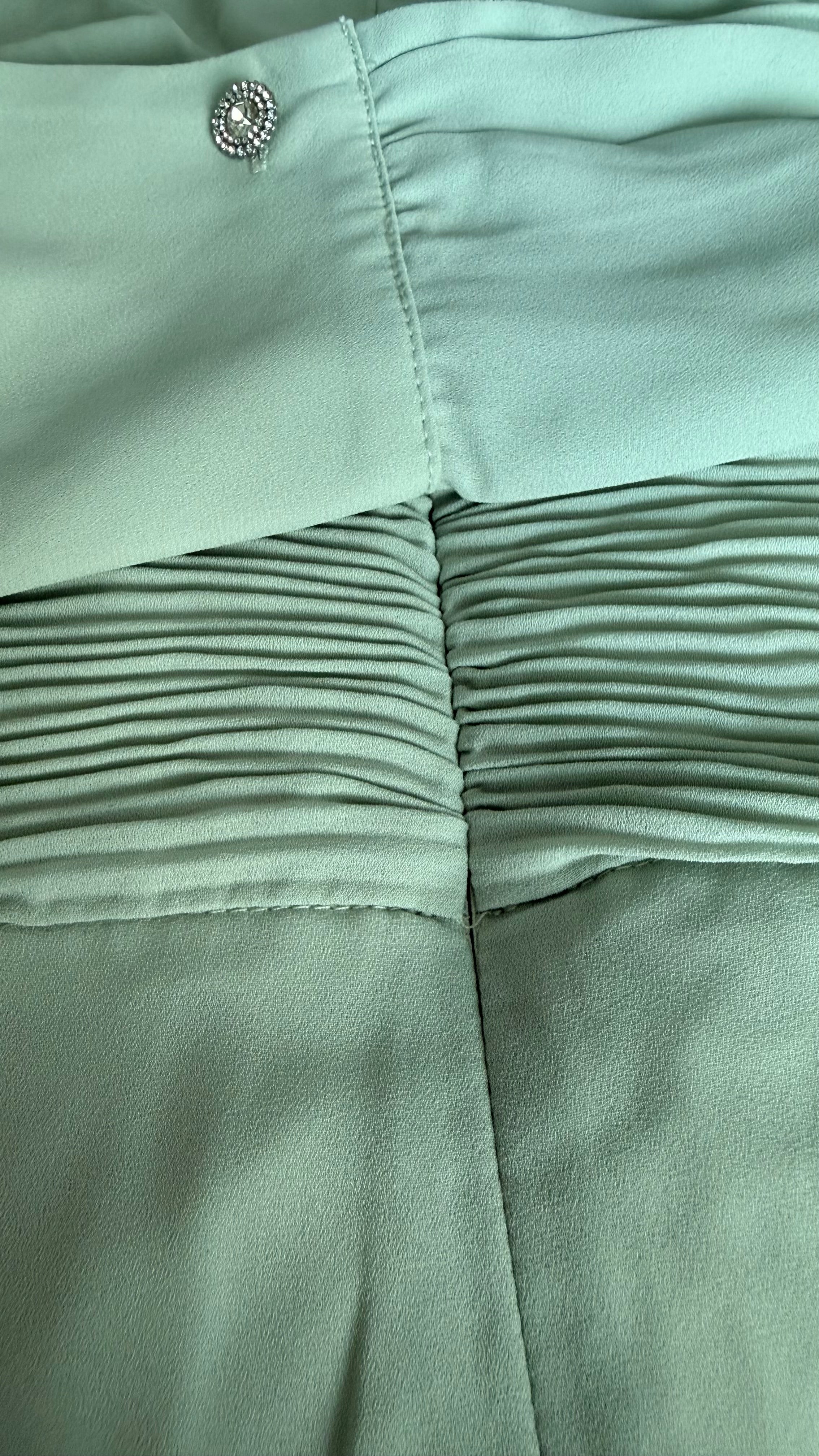 Close-up of light green fabric with a button detail