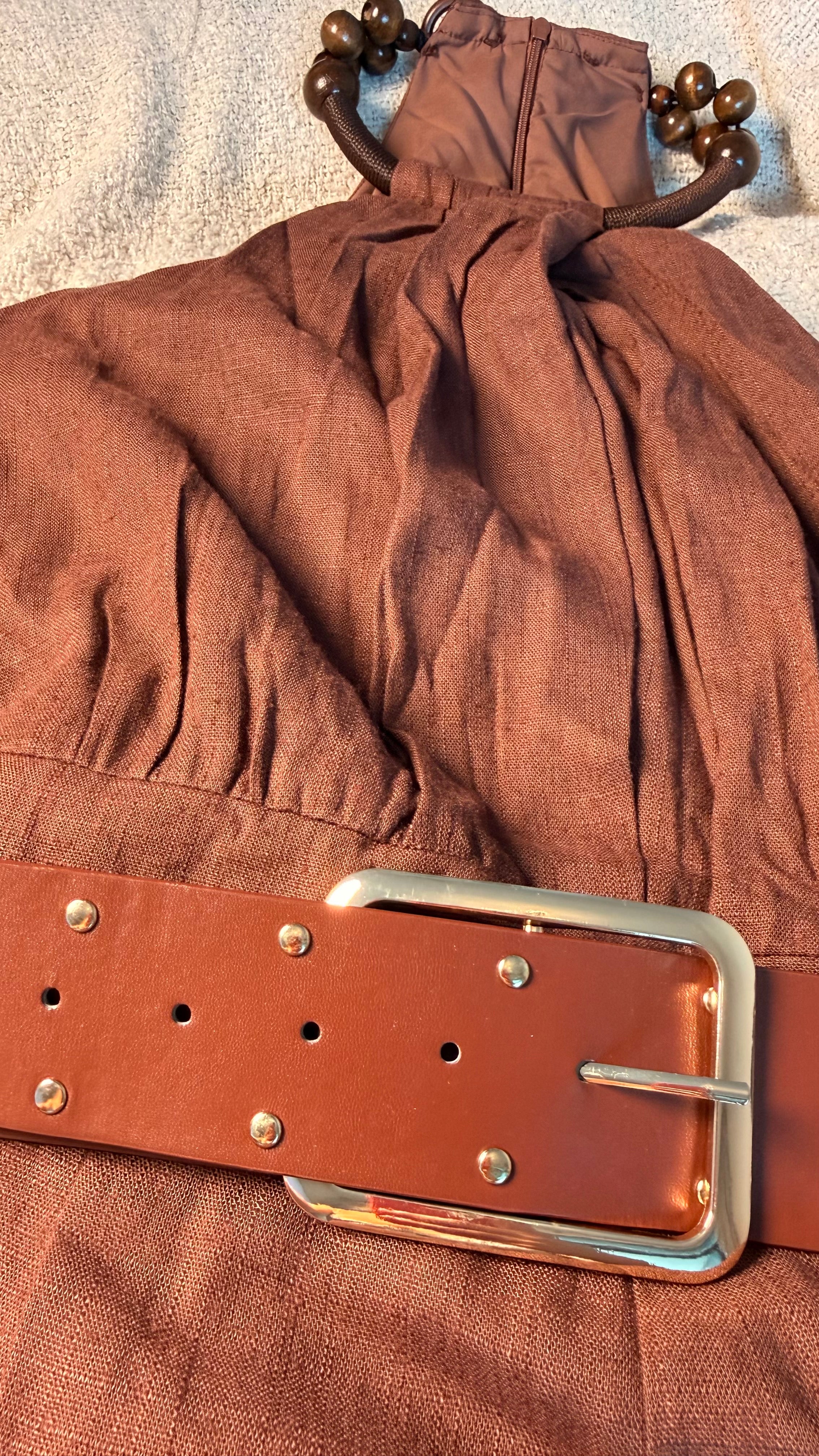 Brown fabric with a leather belt and metal buckle on a textured surface