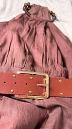 Mauve dress with a red belt and gold buckle on a light background