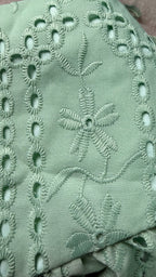 Close-up of green fabric with intricate embroidery