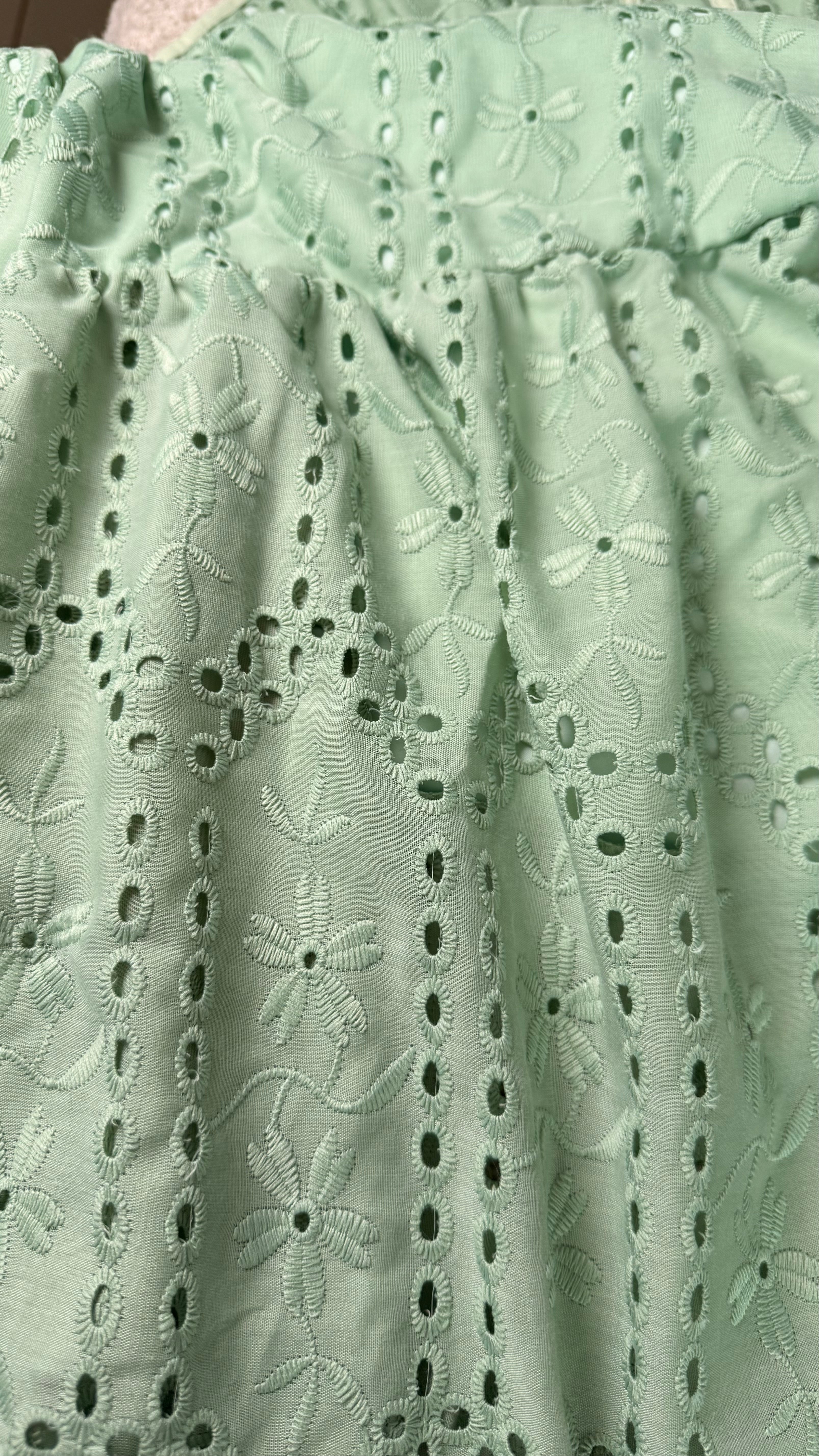 Close-up of light green lace fabric with floral patterns