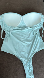 Light  green bodysuitsset on a brown surface