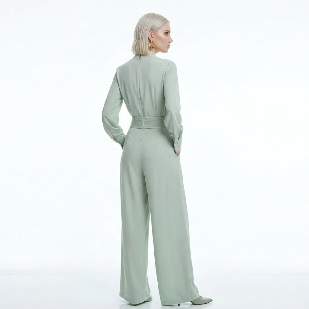 Woman wearing a light green jumpsuit on a white background