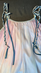 Pink dress with braided straps on a brown surface